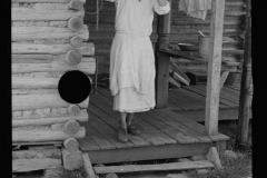 0615_ Housewife outside traditional wooden country dwelling