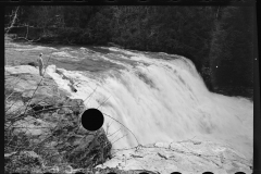 1619_ Man on rock observing river in spate ,Fall Creek