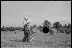 1867_Pride of harvest, hay stooks  farmer with son 