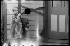 1907_ Young girl carrying clothes  . Light ingress to neg.