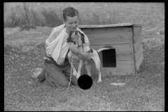 1974_Young boy with broken arm and pet dog and kennel.