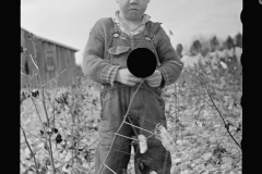 2175_ Sad small boy in  cotton field  with   rock-strewn soil