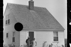 3086_Resettled farmer on steps of  their new home, Wabash Farms,