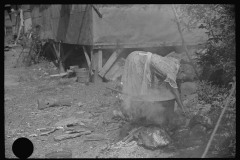 3624_ African-American woman washes clothes outside the shack