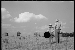 1873_Pride of harvest, hay stooks  farmer with son , unknown location.