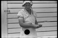 Wife probably having harvested corn form domestic plot , unknown location