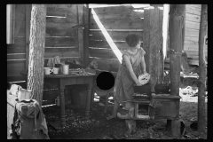 2071_Twelve-year old girl of family of nine, cooking meal in-open lean-to  hut, Tennessee