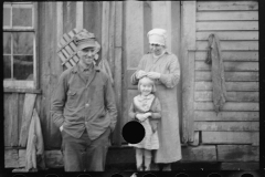 2472_ Rehabilitation  family (smiling ) outside their old home