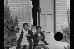 2930_ children sitting on the doorstep of their new home , Newport News Homesteads,