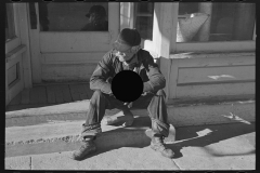 3043_. Old man sitting on a store step .  Arnegard, McKenzie County, North Dakota