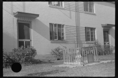 3783_ Child in a 'play -pen'  , front of house , Greenbelt, Maryland