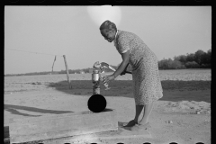 3938_Wife of resettled farmer at the pump . Roanoke Farms, North Carolina