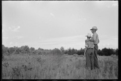 1875_Pride of harvest, hay stooks  farmer with son , unknown location.