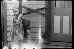 1907_ Young girl carrying clothes at unknown location . Light ingress to neg.