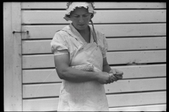 Wife probably having harvested corn form domestic plot , unknown location