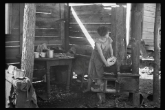 2071_Twelve-year old girl of family of nine, cooking meal in-open lean-to  hut, Tennessee