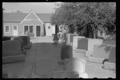 3379_Girl playing among tombstones, Lexington, Nebraska.  H L Lammers , monumental masons.