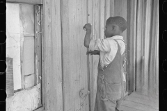 3525_Child of  sharecropper, playing primitive  violin made of stretched wire . Missouri.