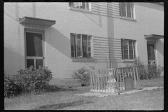 3783_ Child in a 'play -pen'  , front of house , Greenbelt, Maryland