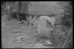 3624_ Black-American woman washes clothes outside the shack