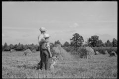 1867_Pride of harvest, hay stooks  farmer with son , unknown location.