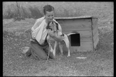 1974_Young boy with broken arm and pet dog and kennel.