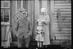 2472_ Rehabilitation  family (smiling ) outside their old home