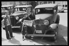 2500_ Boys selling newspapers perched on the front wing of a Ford  4 door sedan , Jackson Ohio