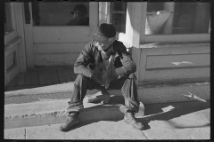 3043_. Old man sitting on a store step .  Arnegard, McKenzie County, North Dakota