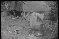 3624_ Black-American woman washes clothes outside the shack