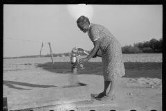 3938_Wife of resettled farmer at the pump . Roanoke Farms, North Carolina