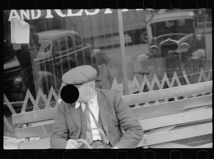 0486_ Man on bench, cars in reflection ,