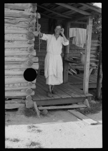 0615_ Housewife outside traditional wooden country dwelling