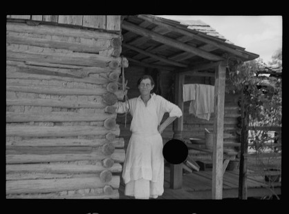 0616_House wife outside wooden country dwelling